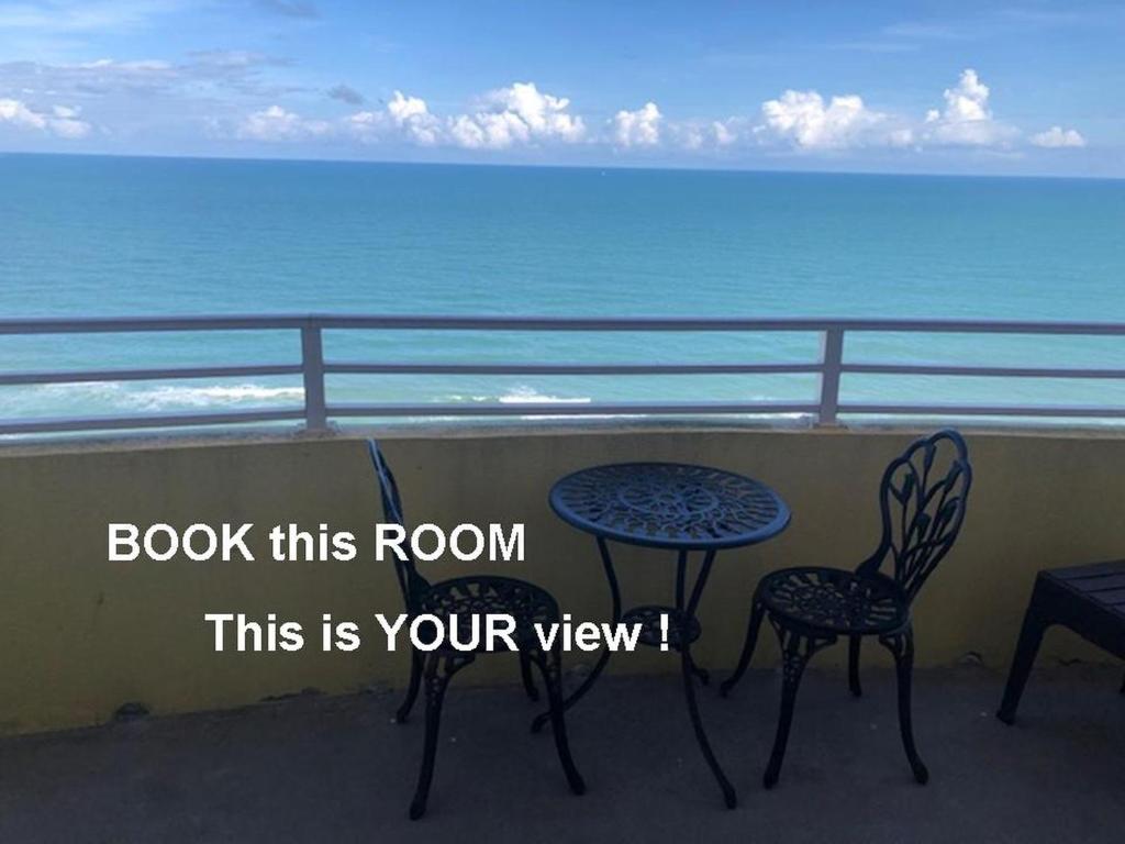 uma mesa e cadeiras numa varanda com vista para o oceano em Ocean Walk Resort 1909 em Daytona Beach