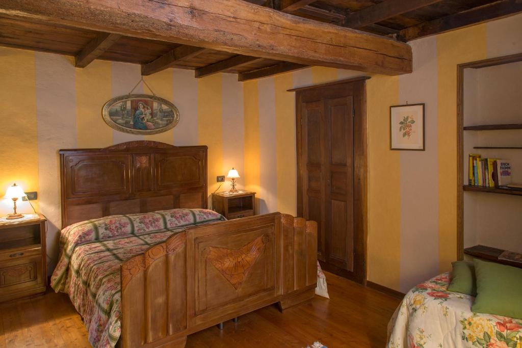 a bedroom with a large wooden bed and two lamps at Agriturismo Oro di Berta in Portula