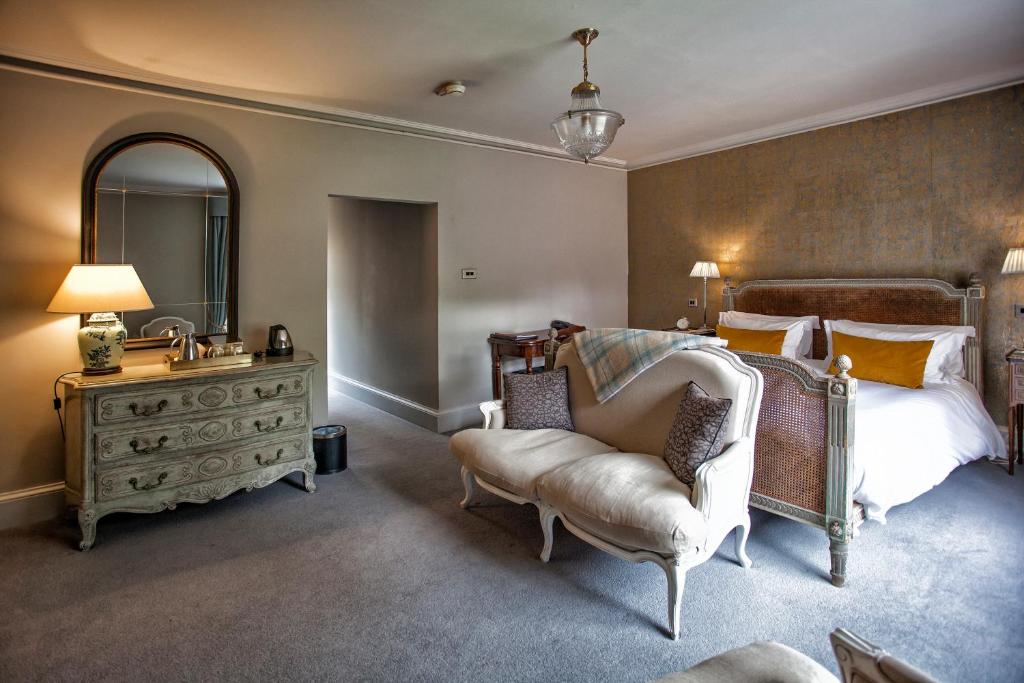 a bedroom with a bed and a chair and a mirror at Grays Court Hotel in York