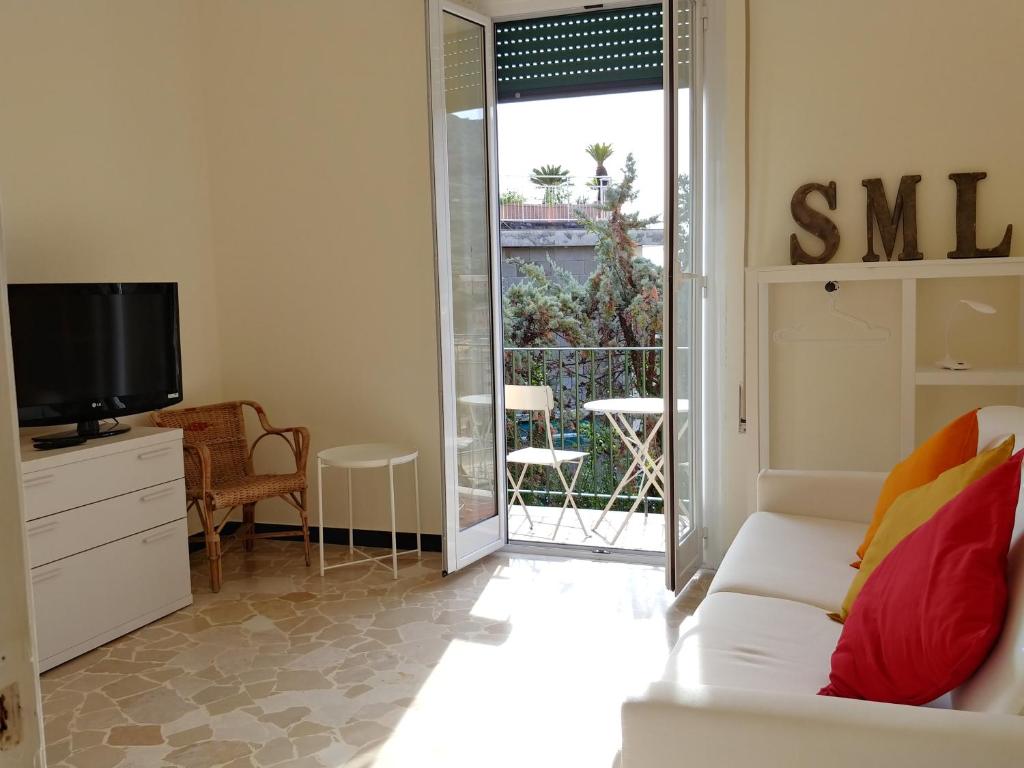 a living room with a white couch and a tv at Casa Tina in Santa Margherita Ligure