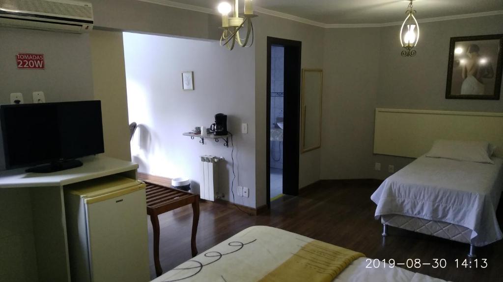Uma cama ou camas num quarto em Pousada do Verde Gramado