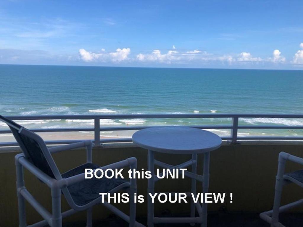 een tafel en stoelen op een balkon met uitzicht op de oceaan bij Ocean Walk Resort 1305 in Daytona Beach