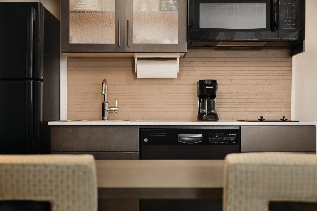 a kitchen with a sink and a dishwasher at Park Inn by Radisson, Calgary Airport North, AB in Calgary