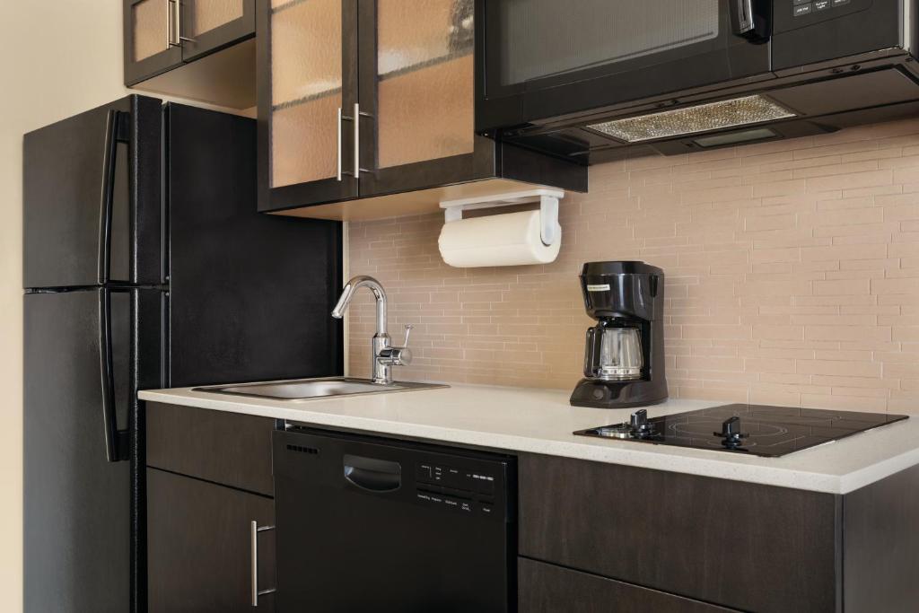 a kitchen with a sink and a refrigerator at Park Inn by Radisson, Calgary Airport North, AB in Calgary