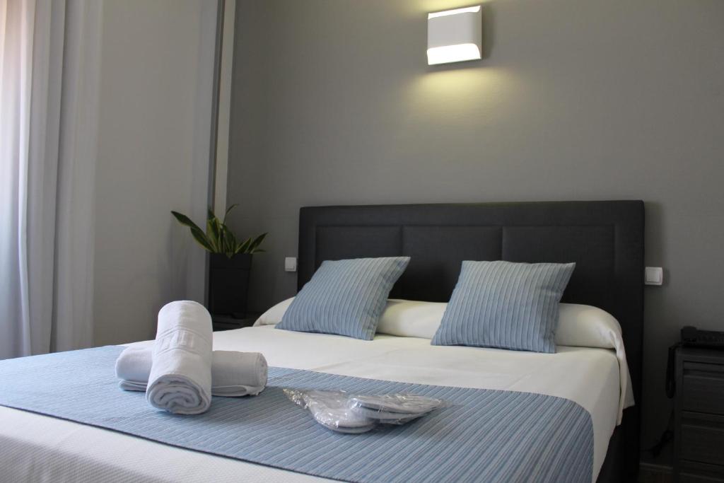 een slaapkamer met een bed met handdoeken erop bij Hotel Barajas Plaza in Madrid