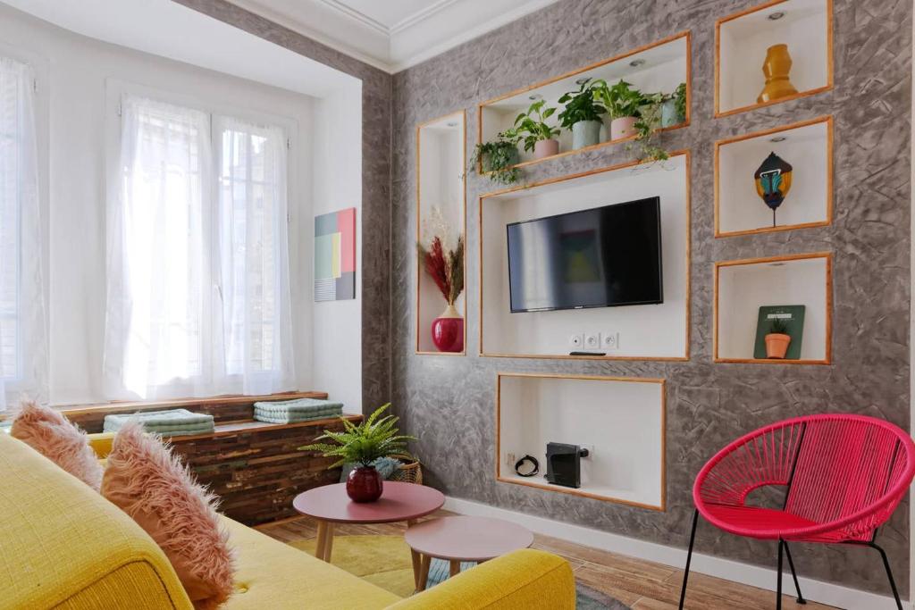 - un salon avec un canapé jaune et une télévision murale dans l'établissement La Perle Marine - 5 min à pied de la Canebière, à Marseille