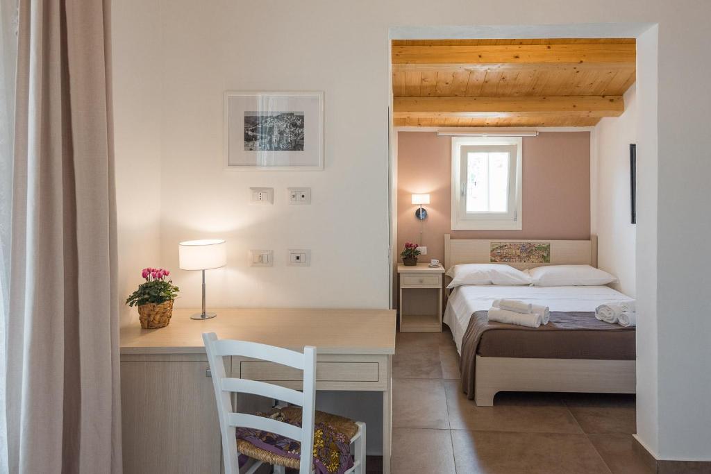 sypialnia z łóżkiem i biurkiem z krzesłem w obiekcie Il Baiocco -Ibla Charme Rooms w mieście Ragusa