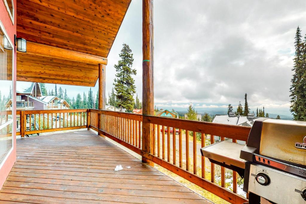 a wooden deck with a grill on a house at DuHaus Green in Big White