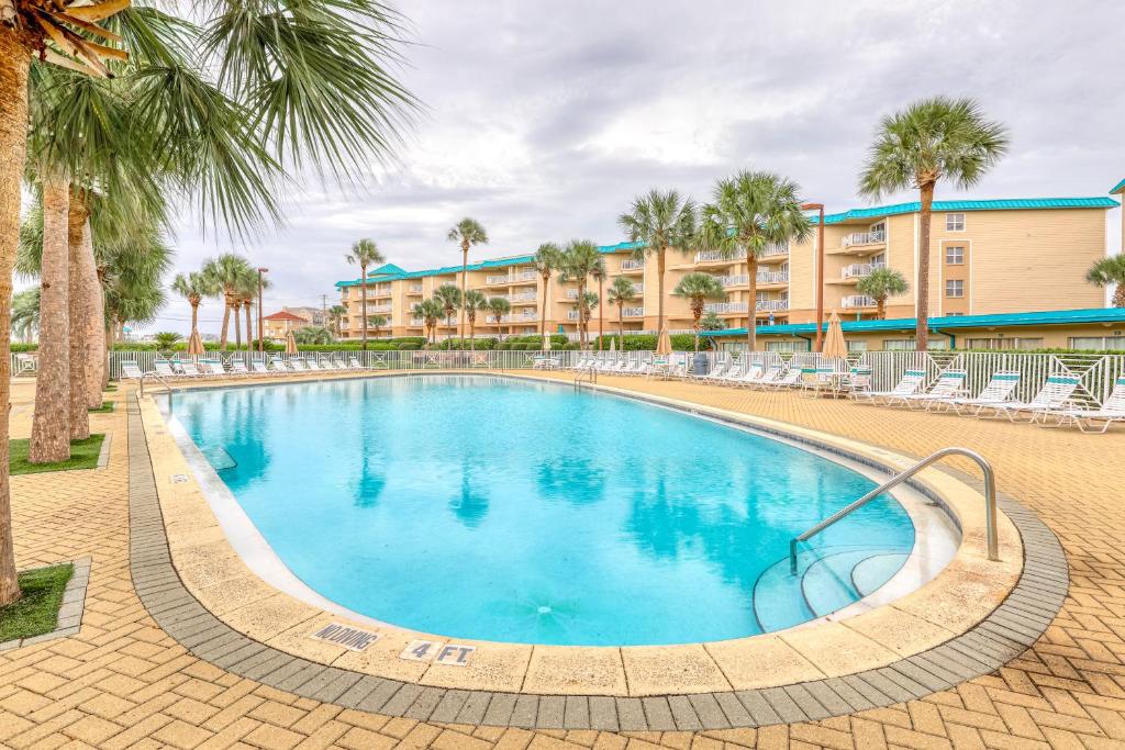 a large pool with chairs and palm trees in a resort at Amalfi Coast in Miramar Beach