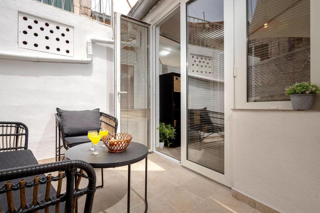 eine Terrasse mit einem Tisch und einem Stuhl auf dem Balkon in der Unterkunft House Heritage in Stari Grad