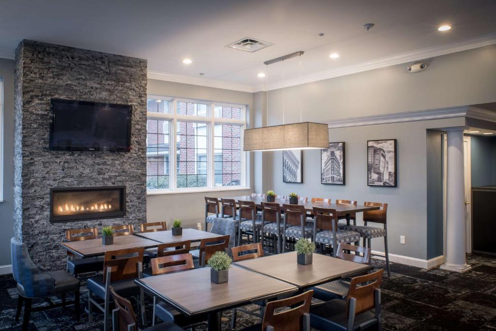 een restaurant met tafels en stoelen en een open haard bij Best Western PLUS Franklin Square Inn in Troy