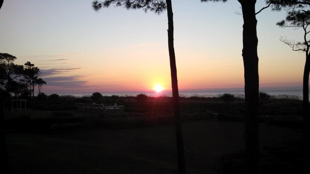 un tramonto con il tramonto in lontananza di Nothing But Ocean in Forest Beach a Hilton Head Island