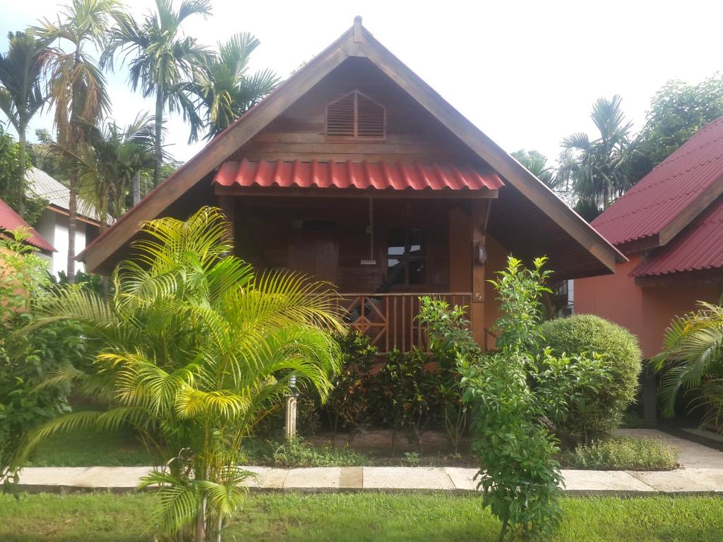 a house with a red awning and palm trees at Phu View Guesthouse in Pai