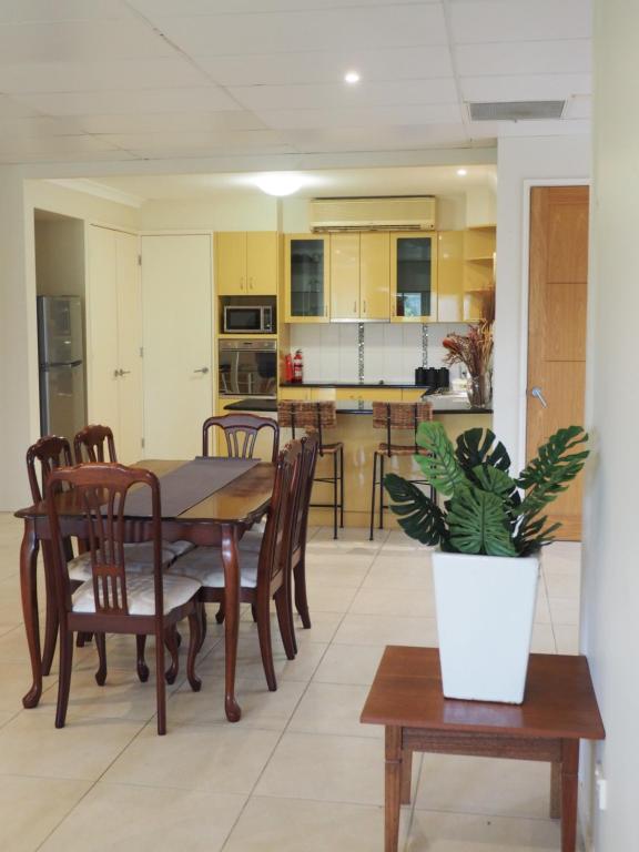 uma cozinha e sala de jantar com uma mesa e um vaso de plantas em Accommodation on Westlake Mount Ommaney em Mount Ommaney