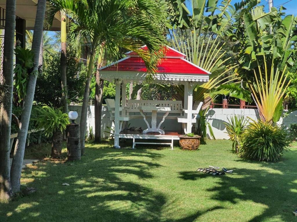 a gazebo with a red roof in a yard at Happy Mind Resort in Sam Roi Yot