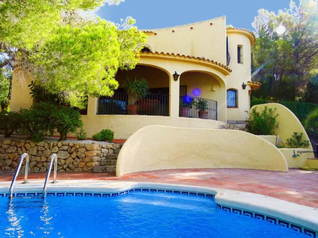 una casa con piscina frente a una casa en Casa Kirbo, en Altea