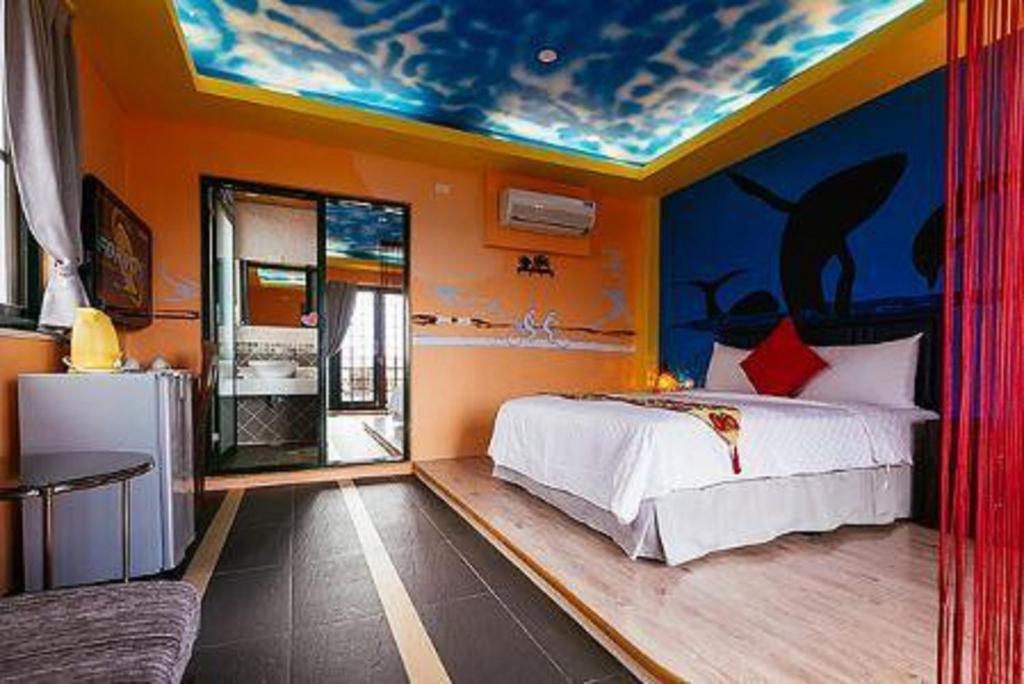 1 dormitorio con 1 cama y una pintura en el techo en Happiness Space, en Hengchun