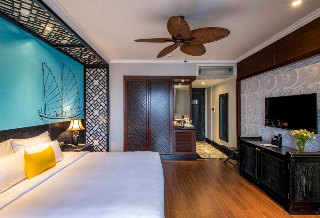 une chambre avec un grand lit avec un ventilateur de plafond dans l'établissement Anio Boutique Hotel Hoian, à Hội An