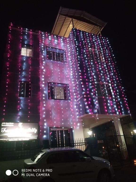 un edificio con luci viola sul lato di Tranquil AC Comfortable stay for Male onlly a Bhubaneshwar