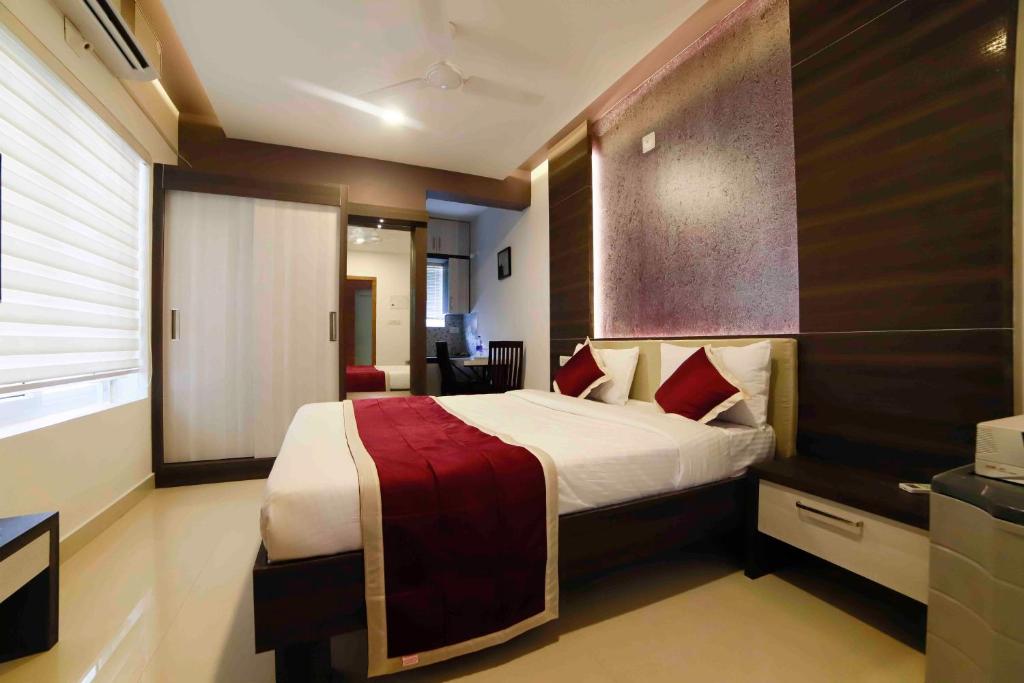 a bedroom with a large bed with red pillows at Ambalath Maple Leaves Home in Guruvāyūr