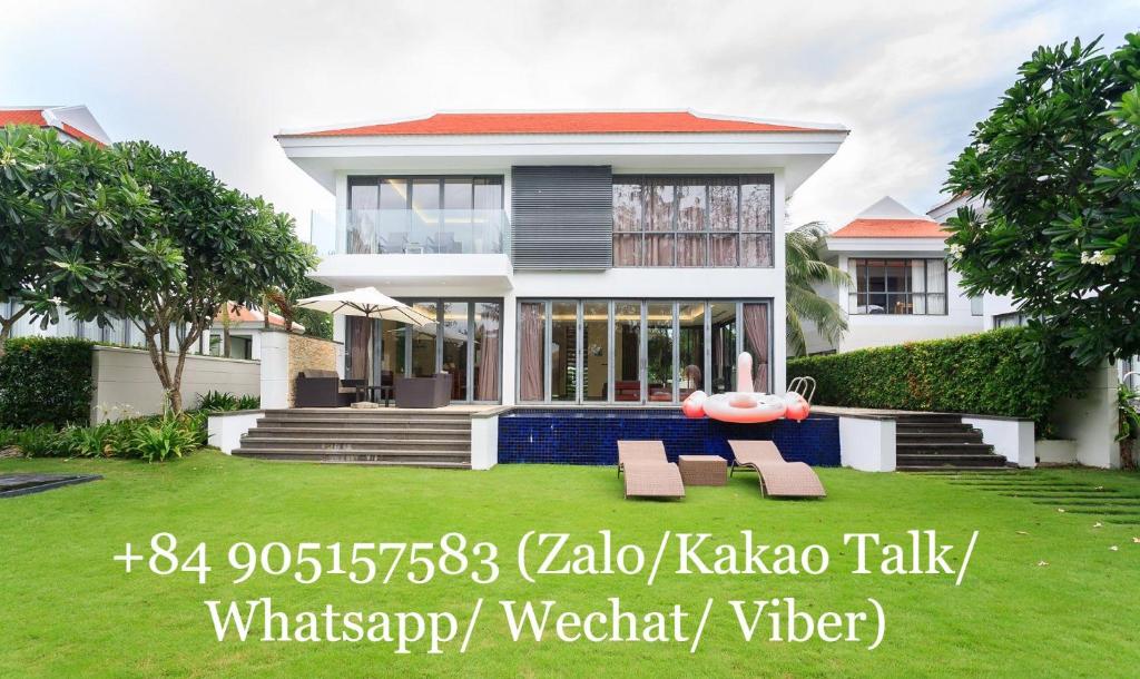 une grande maison blanche avec une pelouse devant elle dans l'établissement Oasis Villa, à Đà Nẵng