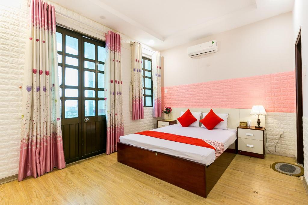- une chambre avec un lit et des oreillers rouges dans l'établissement OYO 373 Habana Hotel, à Hô-Chi-Minh-Ville