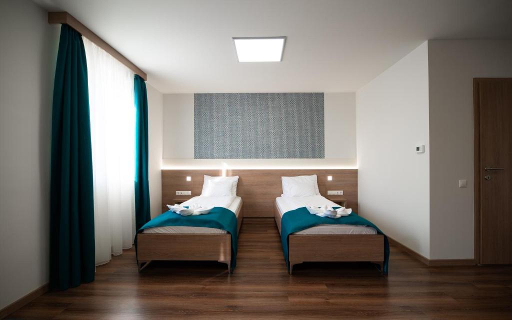 Łóżko lub łóżka w pokoju w obiekcie Hotel Szeghalom