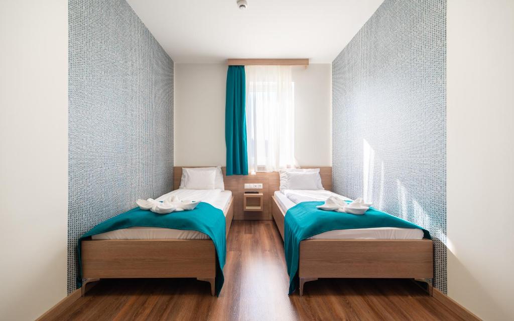 Łóżko lub łóżka w pokoju w obiekcie Hotel Szeghalom