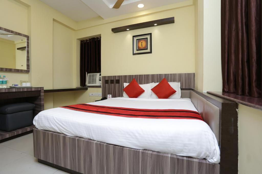 コルカタにあるDiamond Plazaのベッドルーム1室(大型ベッド1台、赤い枕付)
