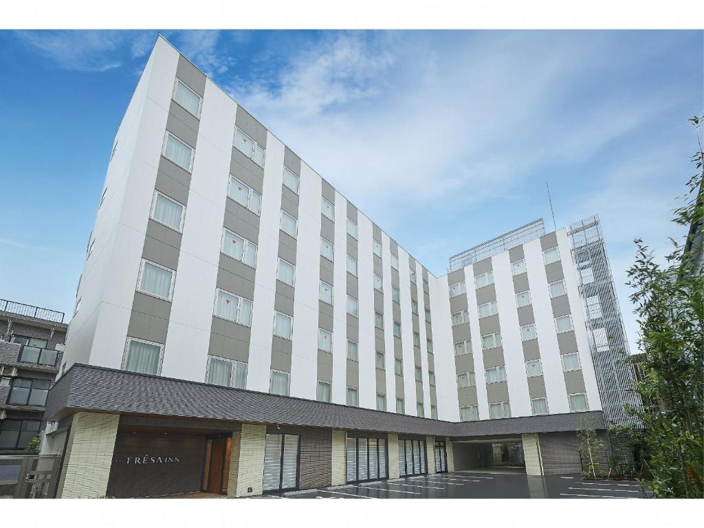 un gran edificio blanco con un cielo en el fondo en Sotetsu Fresa Inn Kamakura-Ofuna Higashiguchi en Kamakura