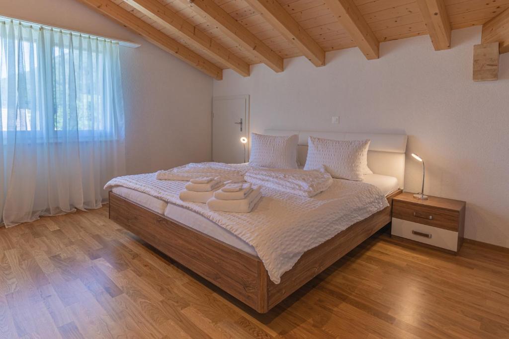 Chalet Gousweid- Jungfrau Apartment في وايلدرسويل: غرفة نوم بسرير كبير عليها منشفتين
