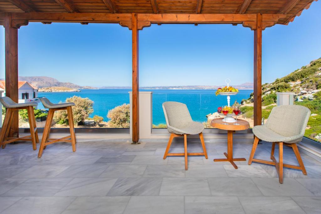 a patio with a table and chairs and a view of the ocean at Villa Almy in Plaka