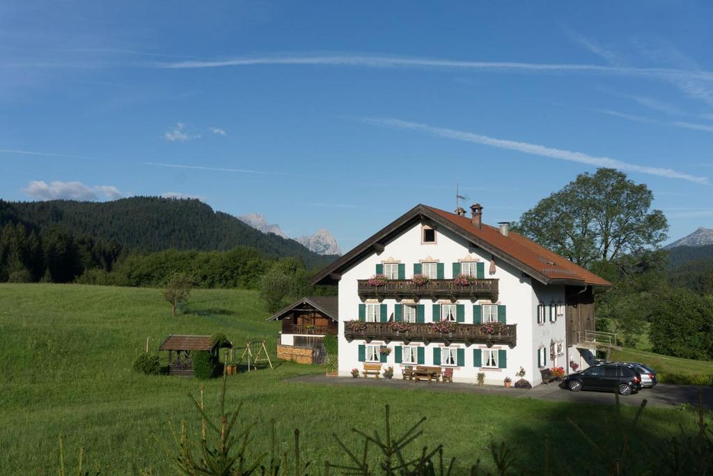 a large white house with a car parked in front of it at Bauernhaus Jocher in Krün