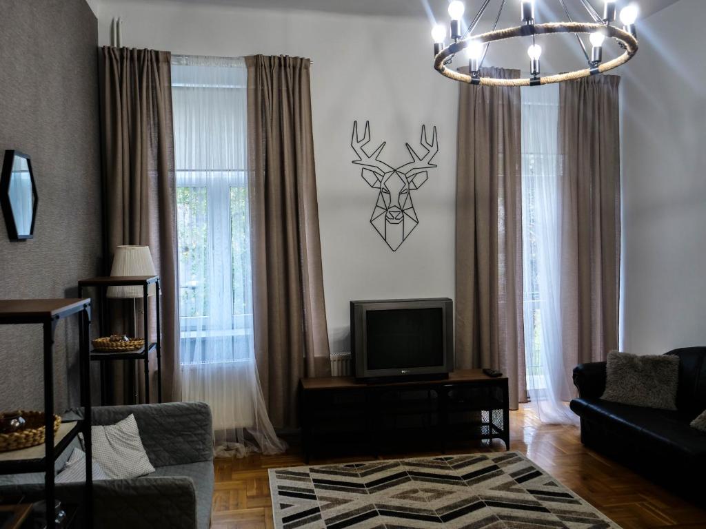 a living room with a tv and a deer head on the wall at Cent Hostel in Lublin