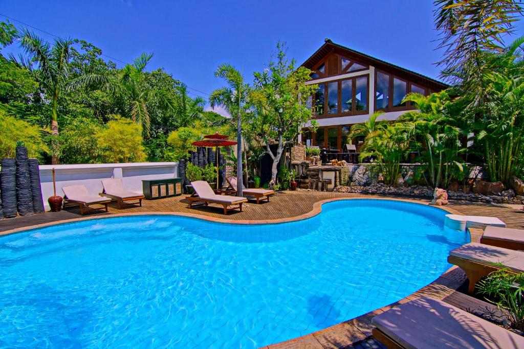 a swimming pool in front of a house at The Hotel by the Red Canal in Mandalay