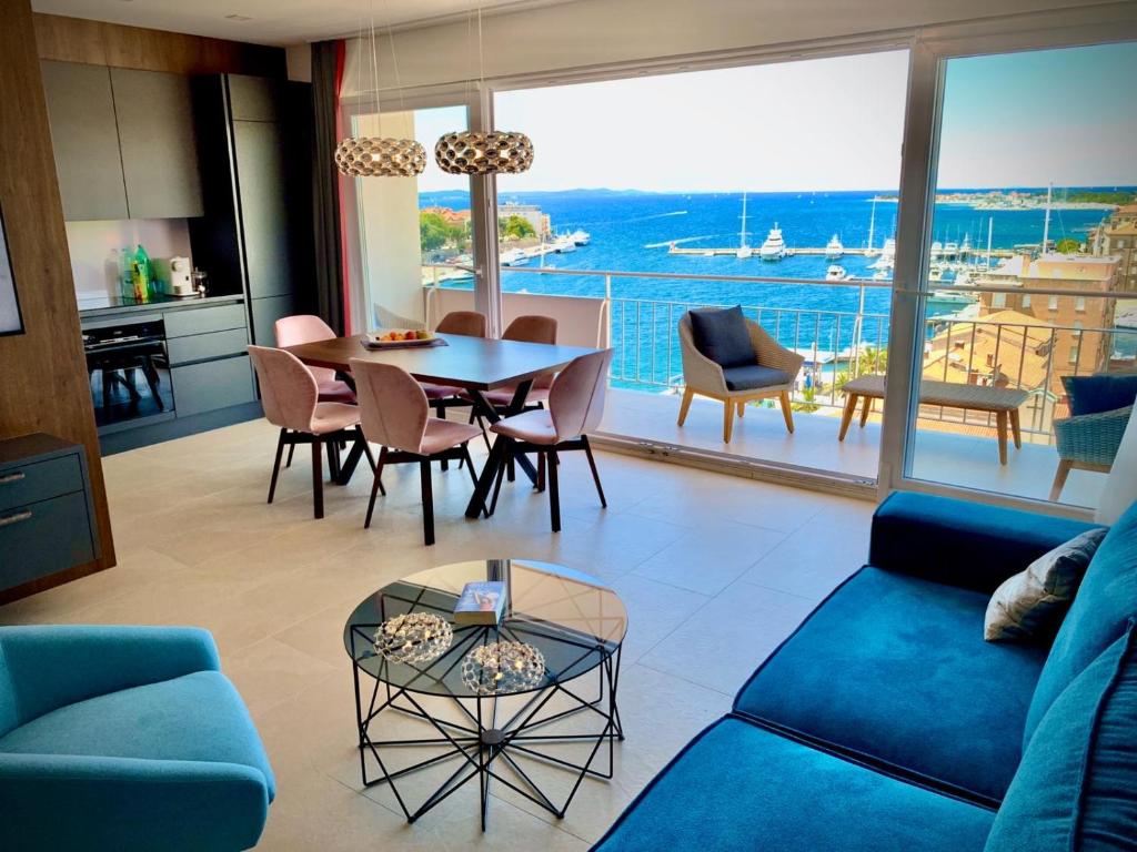 een woonkamer met een blauwe bank en een tafel bij ZADAR Panorama Sea View Apartments in Zadar