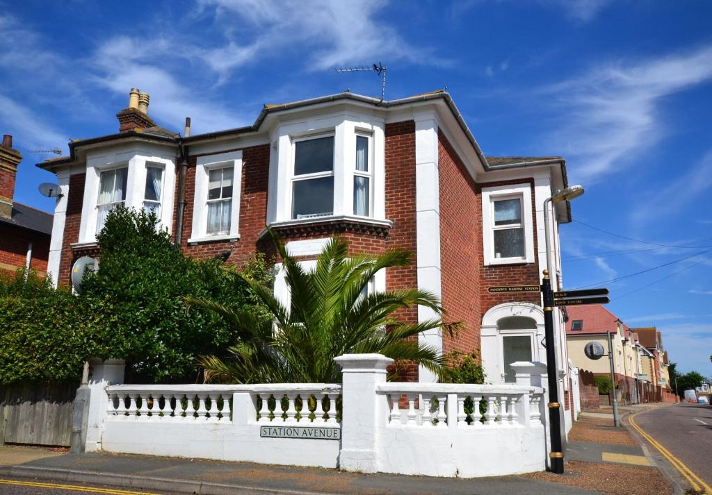 a red brick house with a white fence at Woodleigh in Sandown