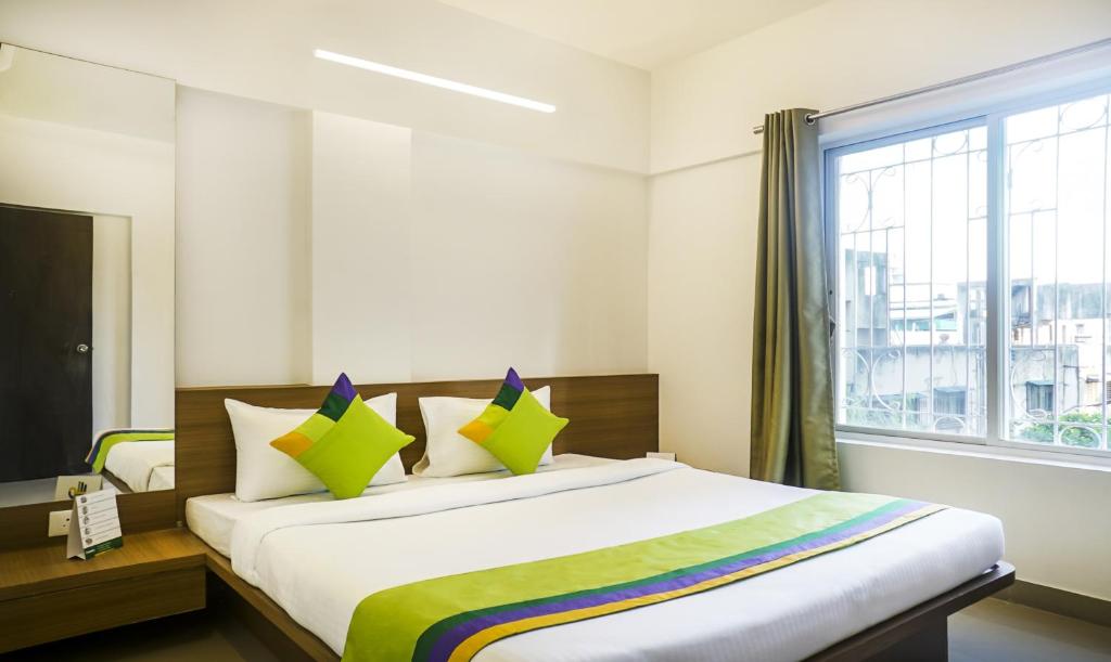 a bedroom with a large bed with a window at Treebo Trend Luxe Suite Shivaji Nagar in Pune