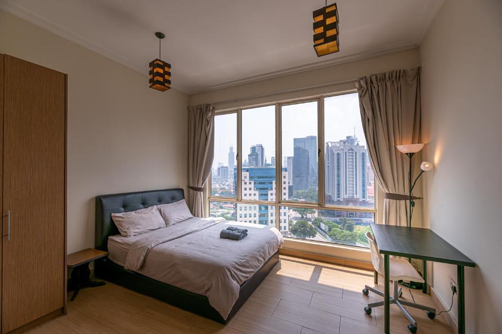 um quarto com uma cama, uma secretária e uma janela em Rex Ollie @ 231 TR Suite em Kuala Lumpur