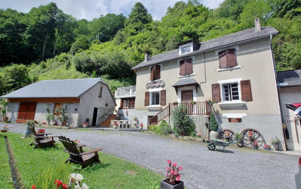 ein großes Haus mit einem Hof mit Bänken davor in der Unterkunft Gite du Hougarou in Ferrières