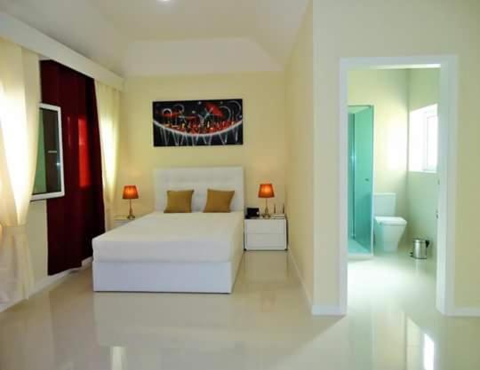 a white bedroom with a bed and a bathroom at São Francisco Accommodation in Funchal