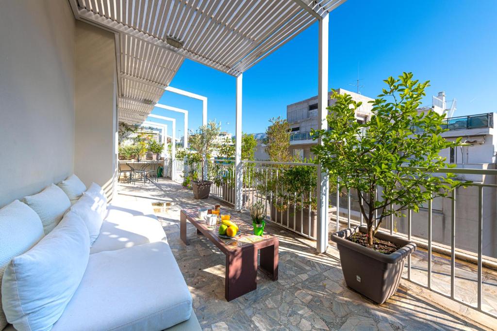 a living room with a white couch on a balcony at Hidesign Athens Luxury Apartments in Kolonaki in Athens
