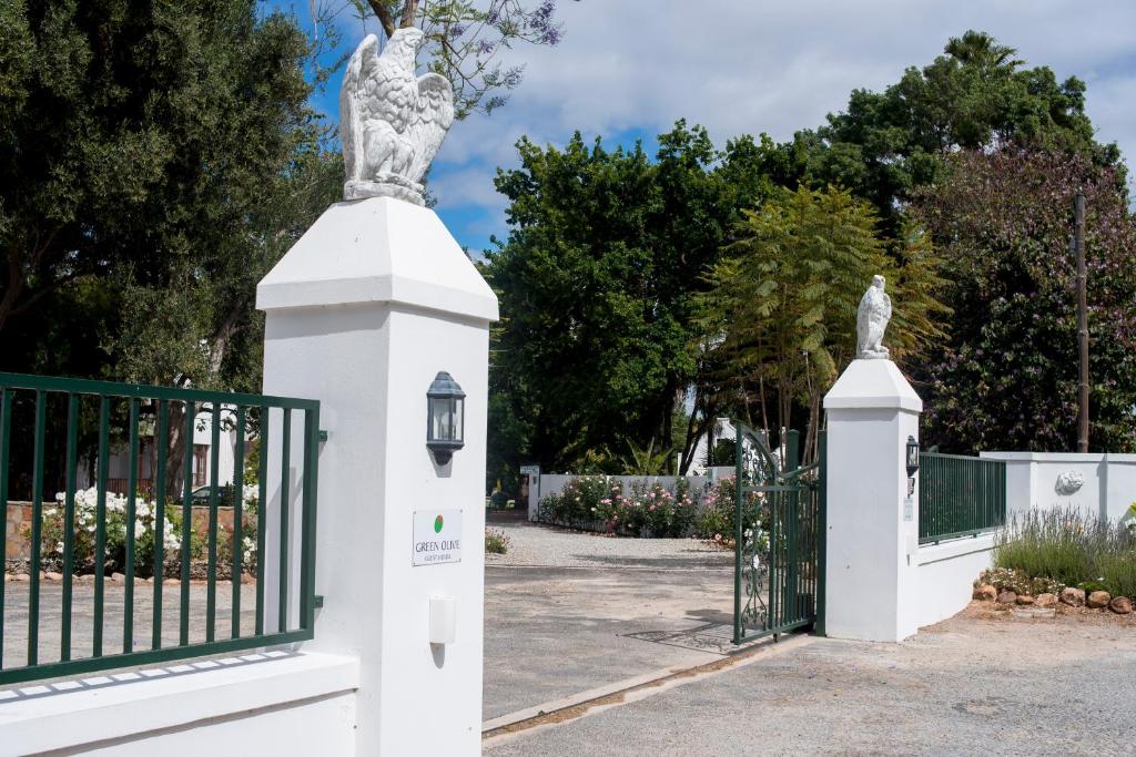 una recinzione bianca con una statua sopra di Green Olive Guesthouse a Robertson