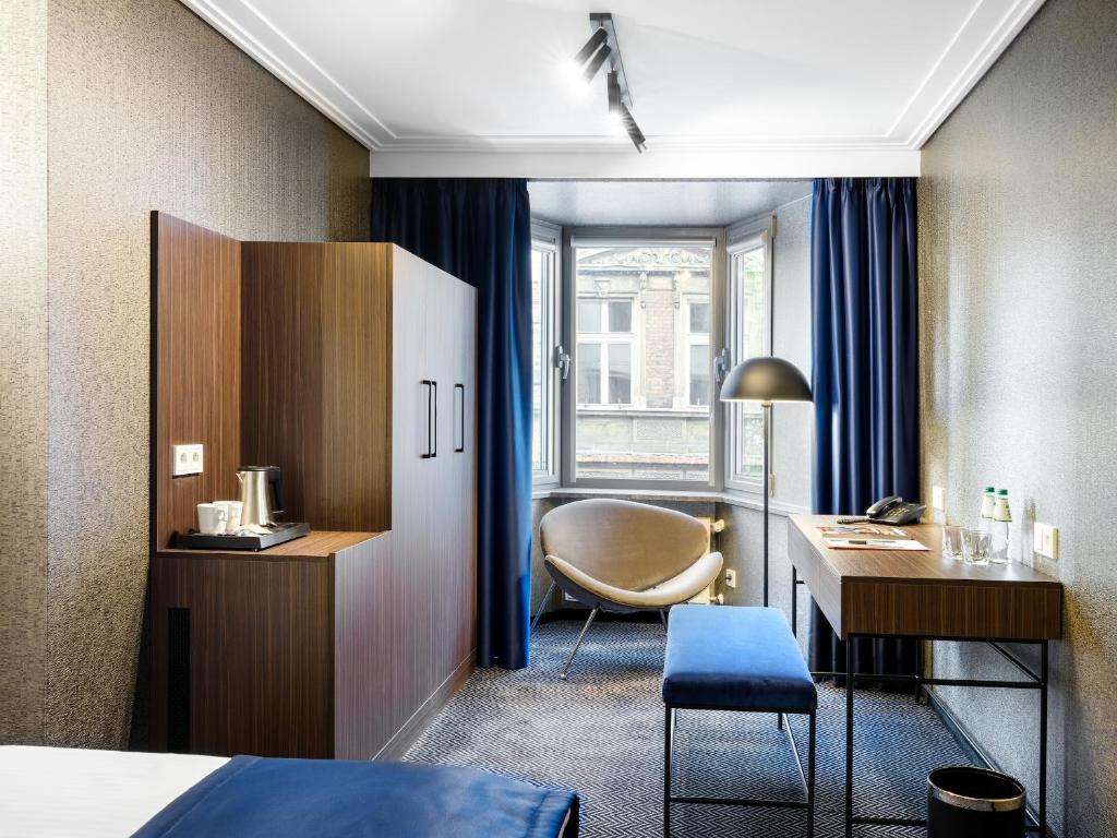 a hotel room with a bed and a desk at Hotel Logos Kraków in Krakow