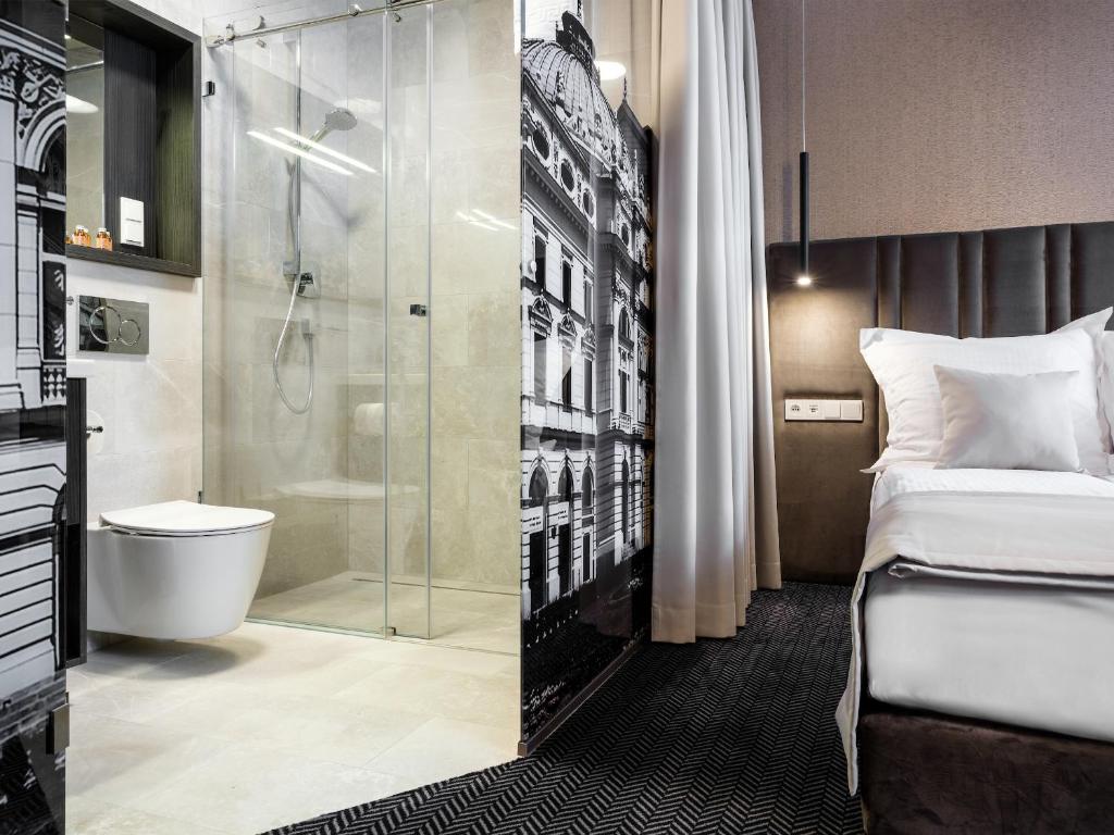 a hotel room with a shower and a bed at Hotel Logos Kraków in Krakow