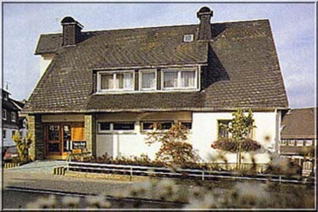 a large white house with a black roof at Pension Braun in Winterberg