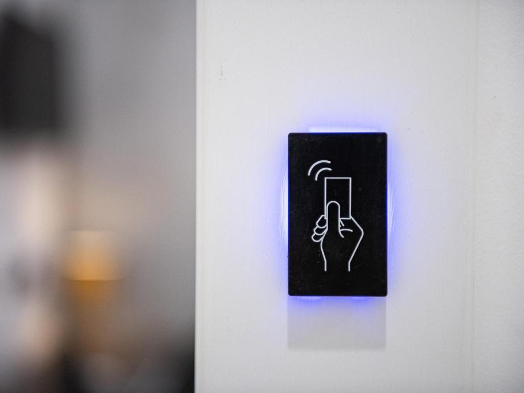 a sign with a hand holding a phone on a wall at Diaz Apartment in Cagliari