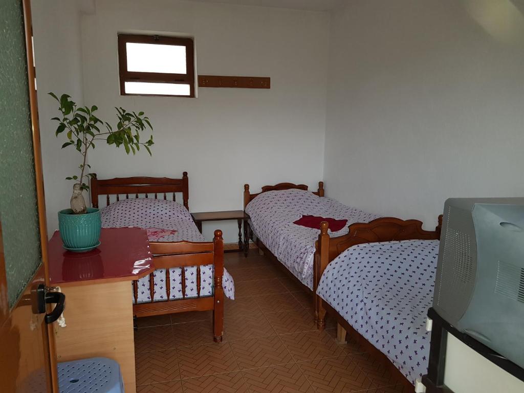 Habitación con 2 camas individuales y TV. en Ensol B&B, en Peshkopi