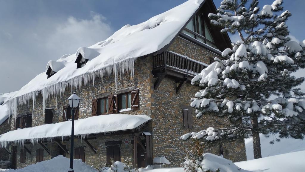 a building covered in snow with icicles at Baqueira Apartamentos Cota 1700 a pie de pistas in Baqueira-Beret