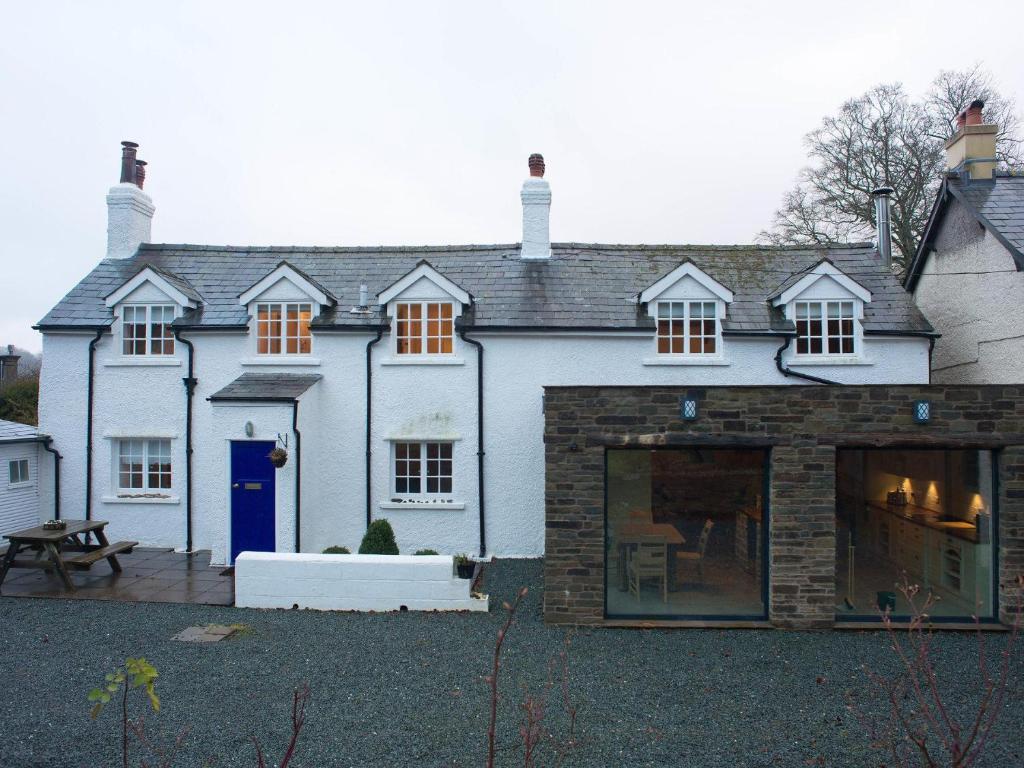 Una gran casa blanca con una puerta azul en Chapel House Cottage en Builth Wells